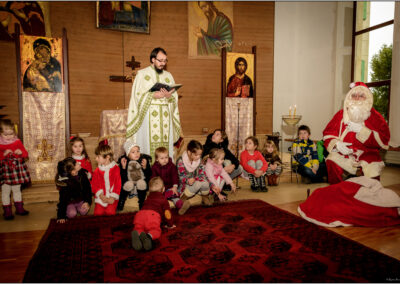 Père Marius lisant une prière aux enfants