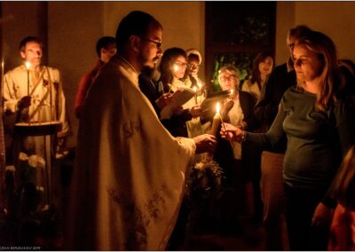 Père Marius transmettant la lumière à une fidèle