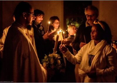 Père Marius transmettant la lumière à une fidèle