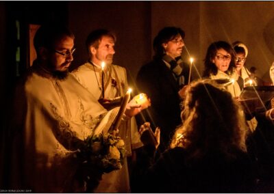 Père Marius transmettant la lumière à une fidèle